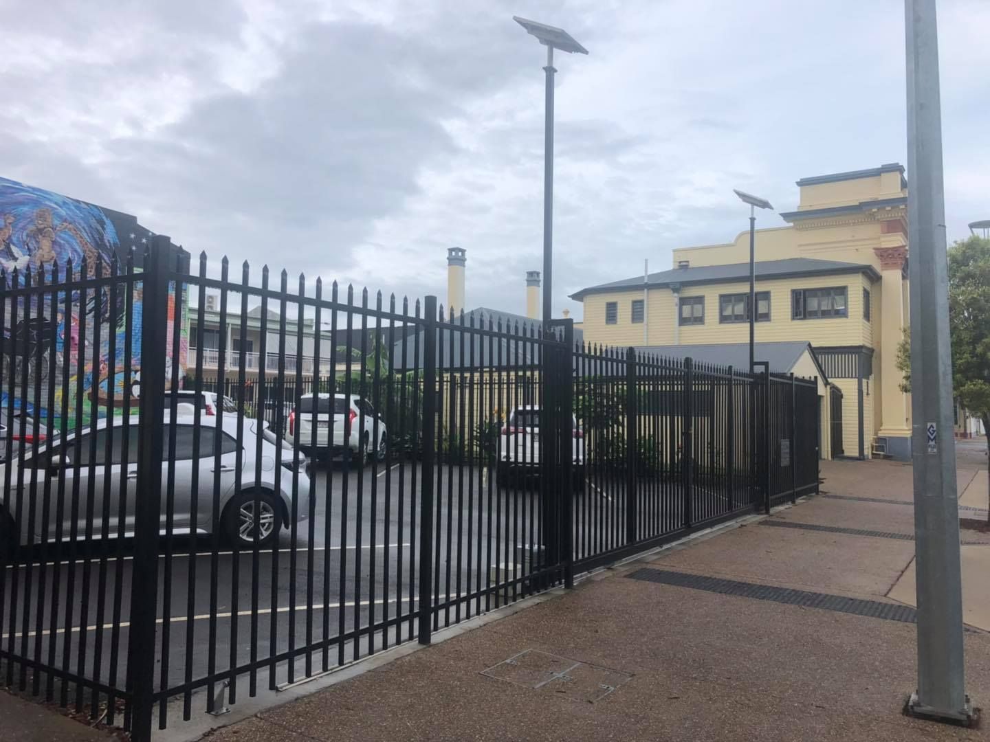Car is Parked in a Parking Lot Behind a Metal Fence — Lange's Fencing and Landscaping Centre in Island Plantation, QLD