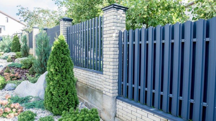 Blue Picket Fence Surrounds a Brick Wall in a Garden — Lange's Fencing and Landscaping Centre in Island Plantation, QLD