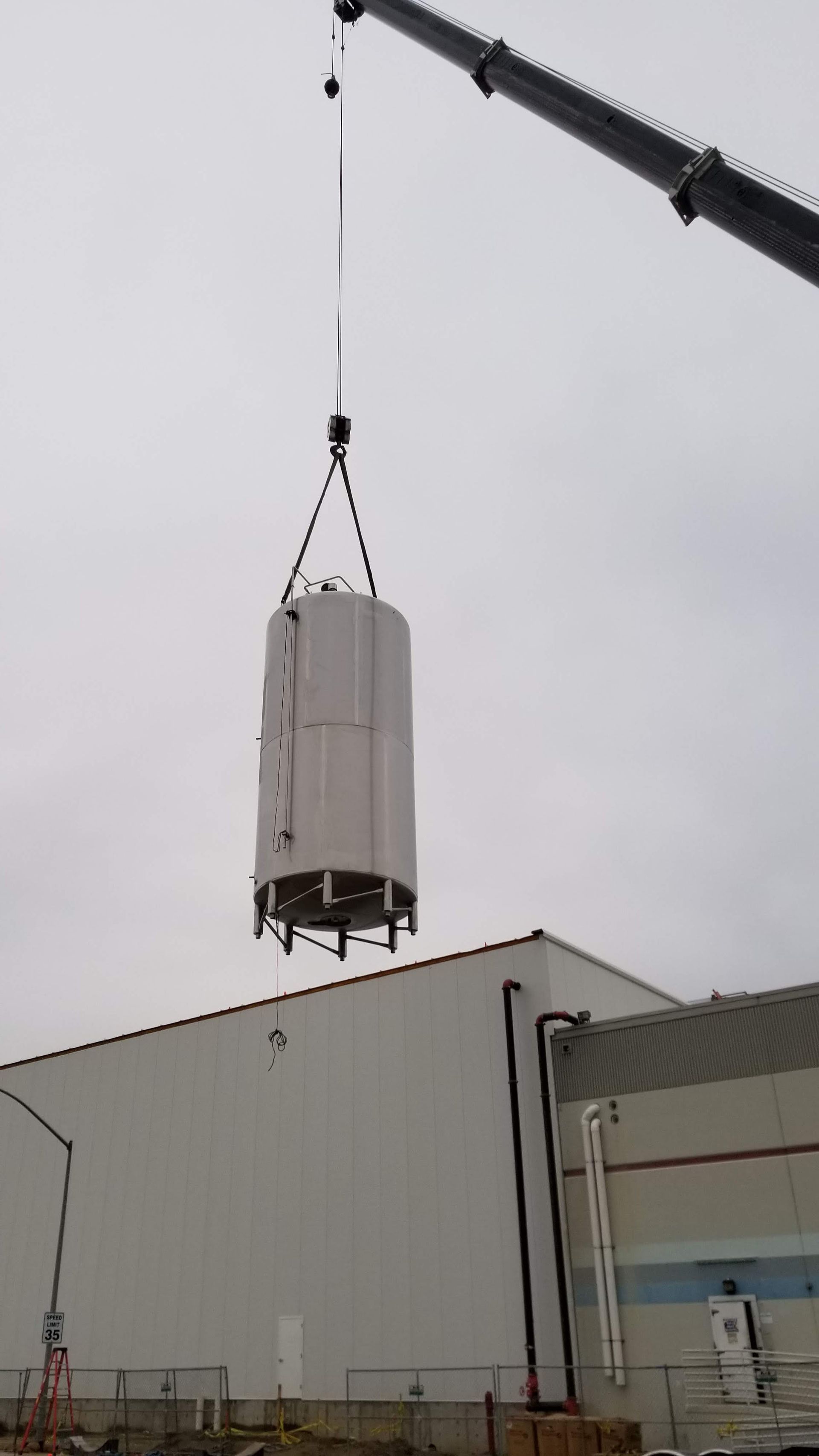A large white object is being lifted by a crane.