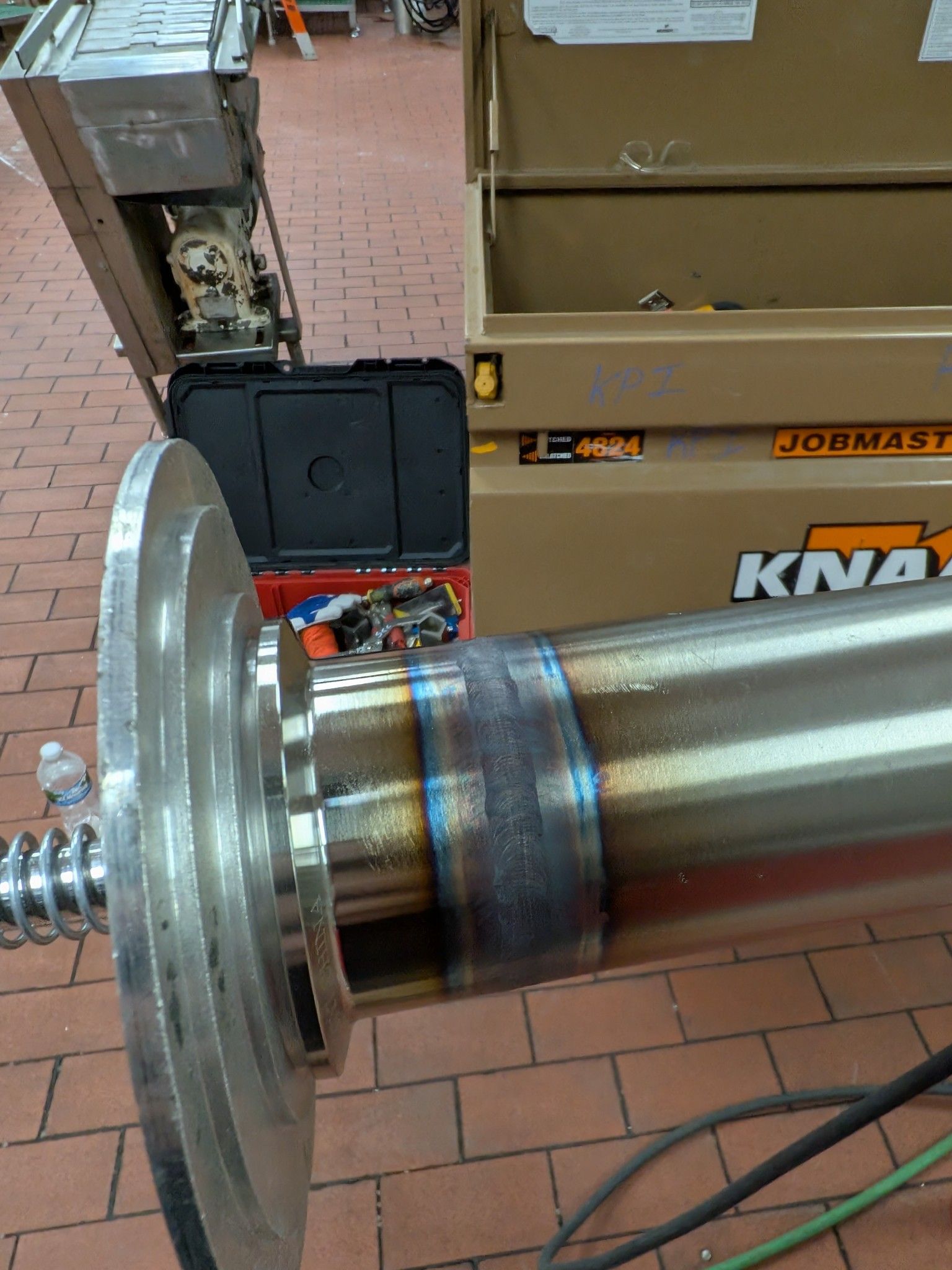 A kna toolbox sits next to a large metal object