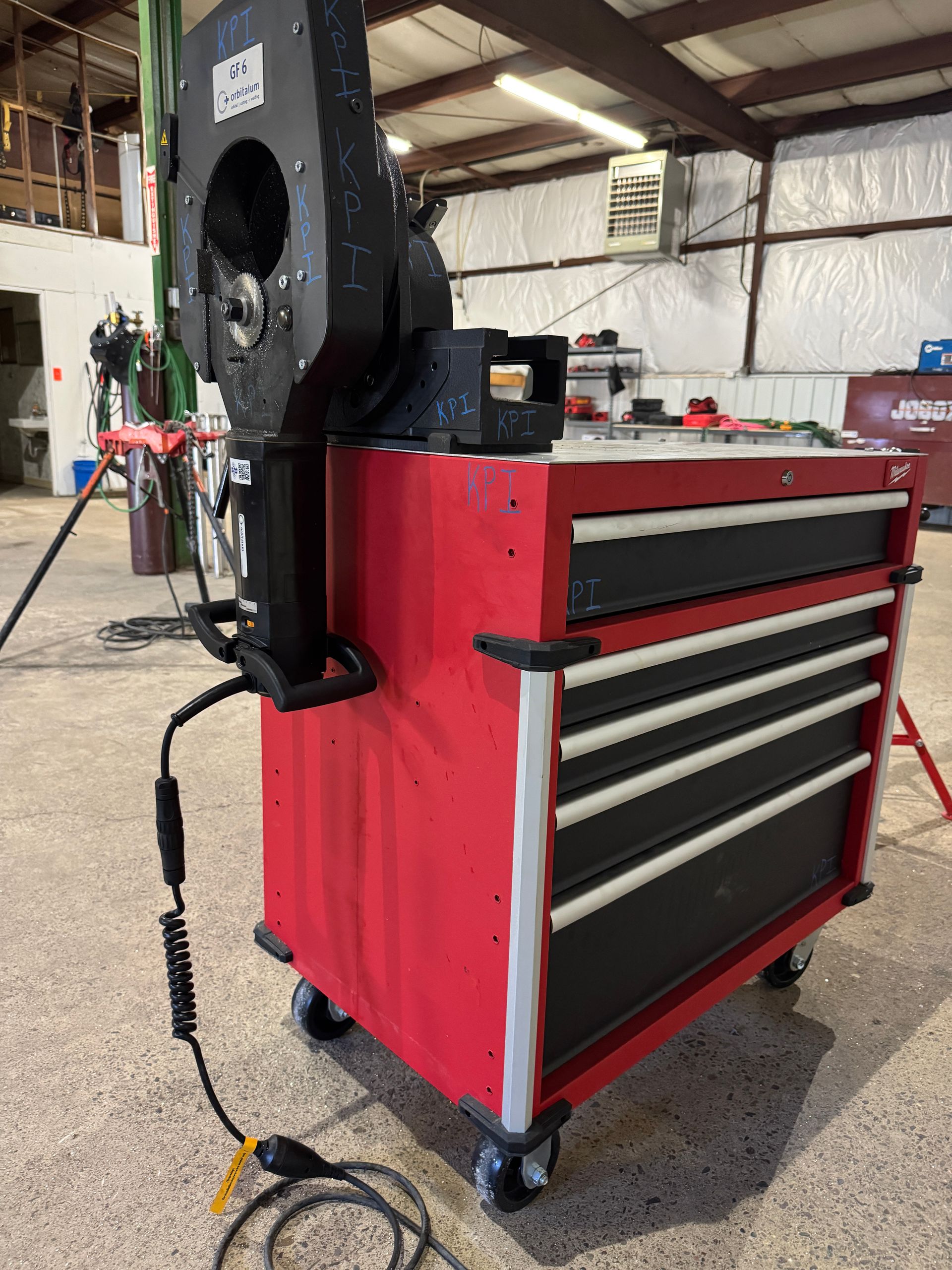 A red toolbox with a fan attached to it in a garage.
