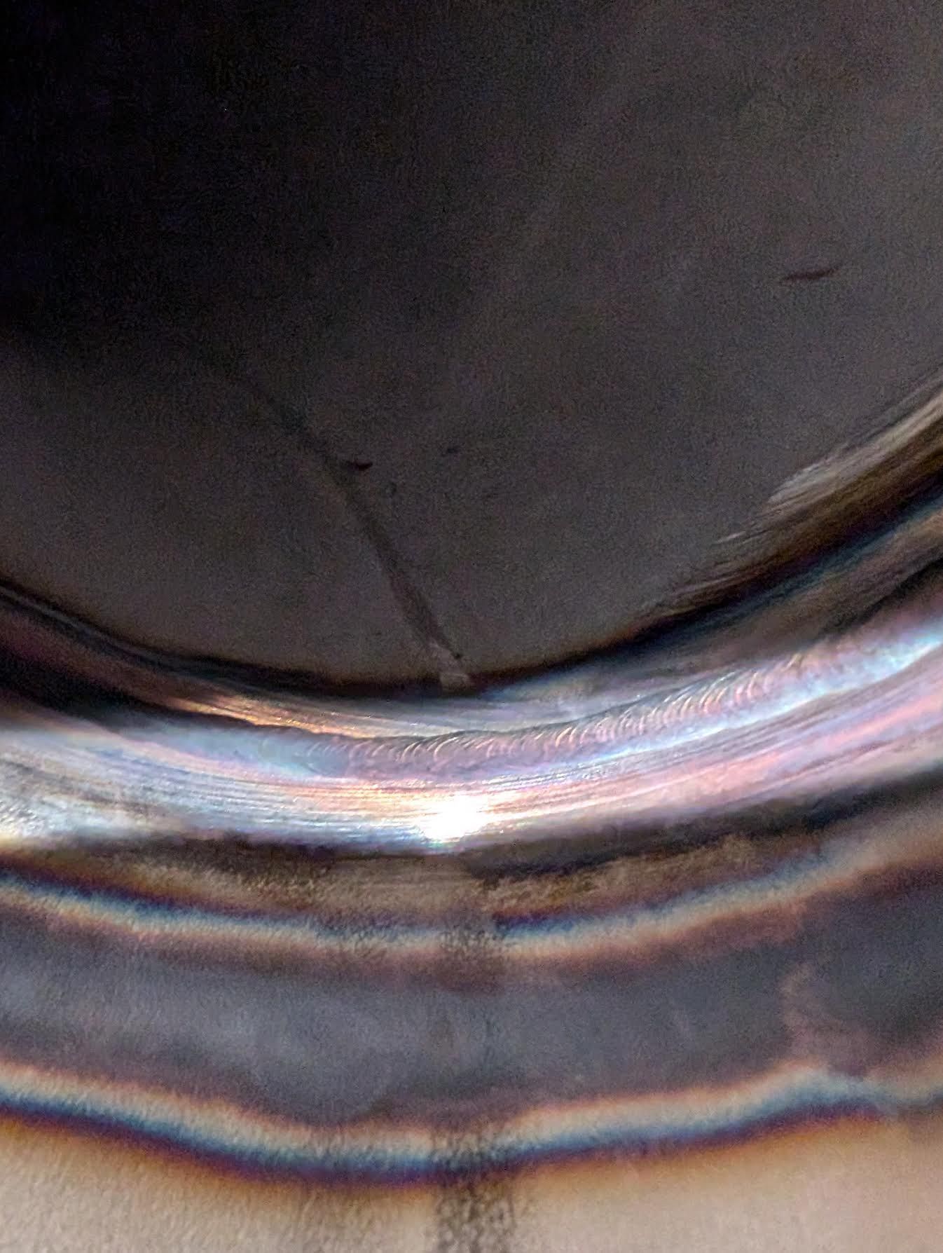 A close up of a metal surface with a rainbow of colors.