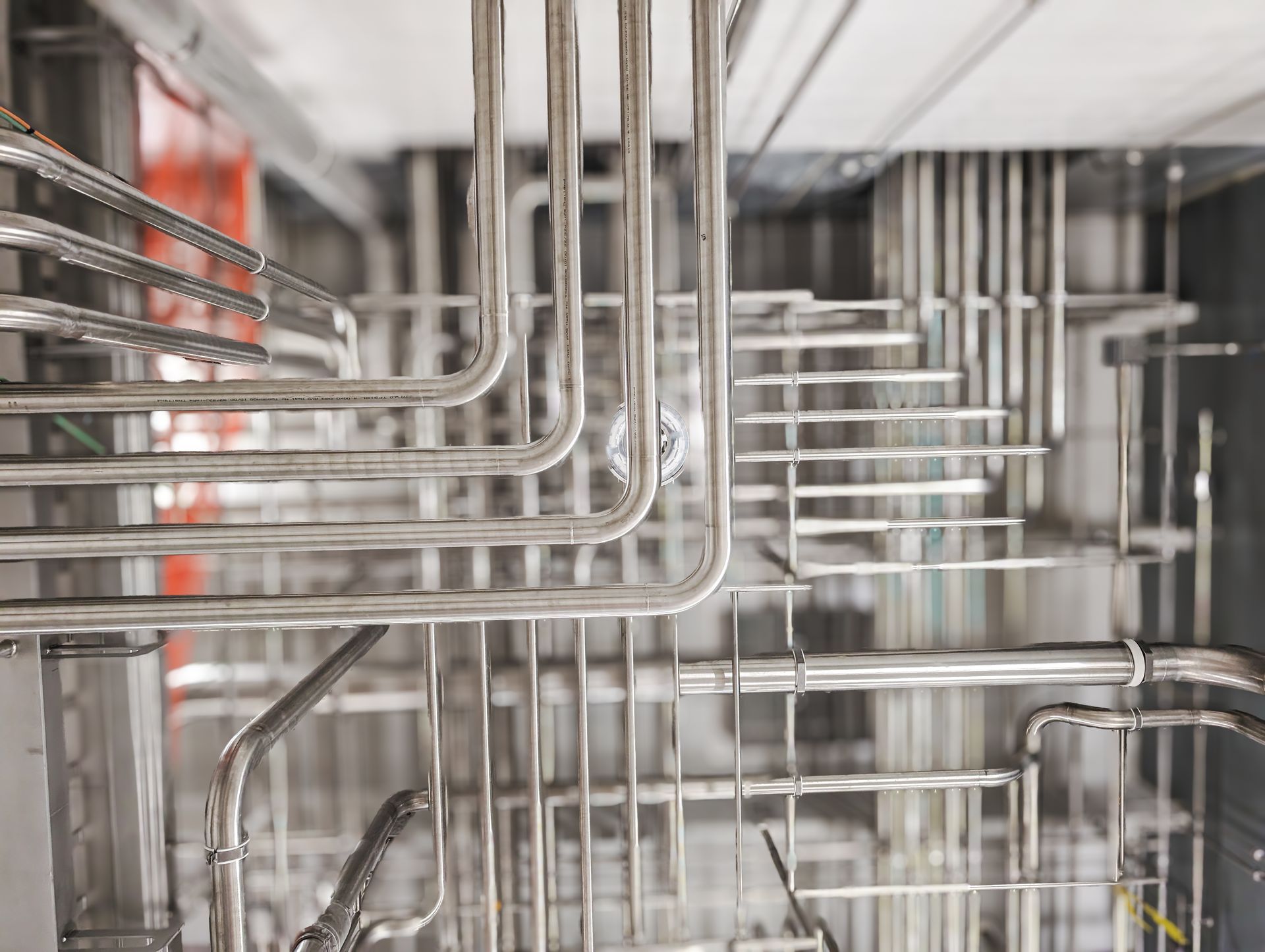 A bunch of stainless steel pipes are connected to each other in a factory.