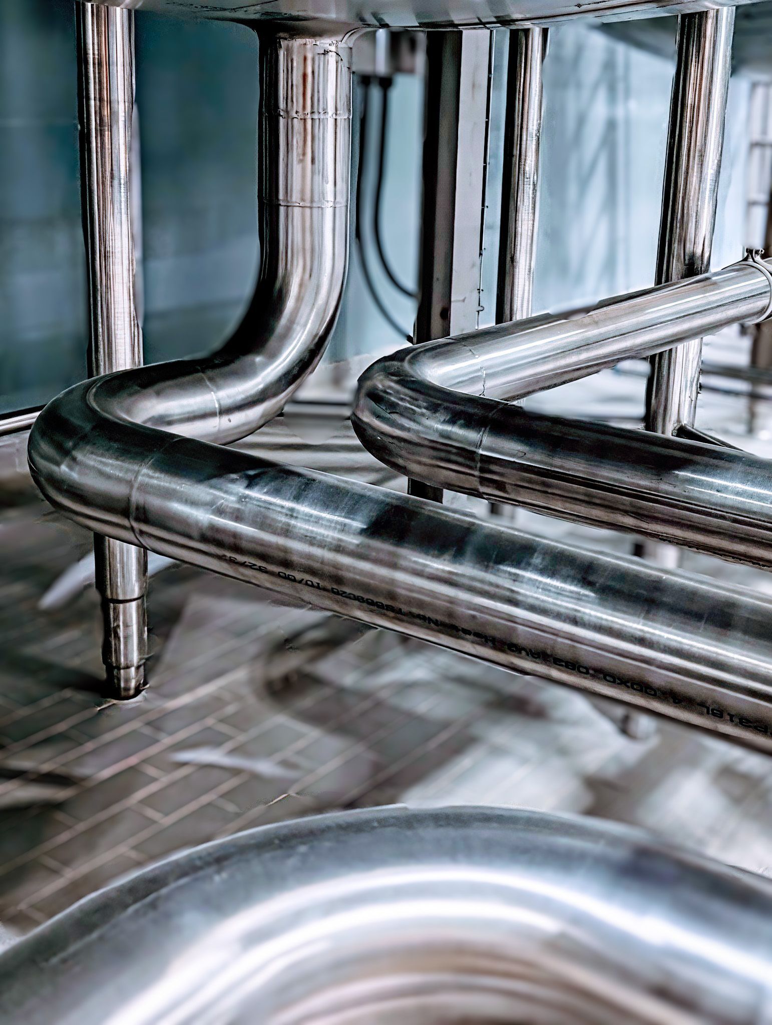 A close up of stainless steel pipes in a factory.