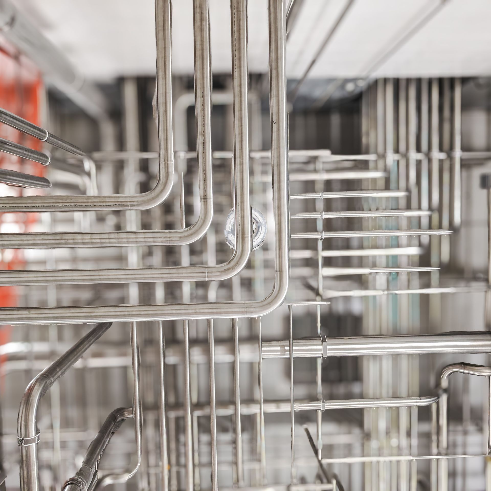 A close up of a dishwasher with a lot of metal pipes