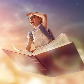Girl with glasses flying on a giant open book, looking up with a joyful expression in a cloudy sky.
