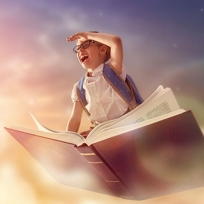 Girl with glasses flying on a giant open book, looking up with a joyful expression in a cloudy sky.