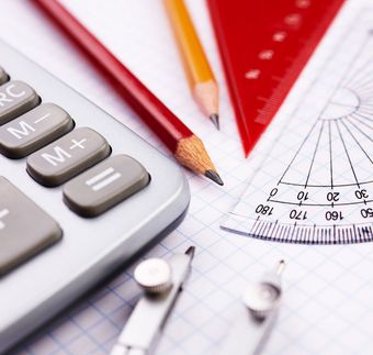 Calculator, pencils, protractor, ruler, and compass on graph paper, tools for math and geometry.