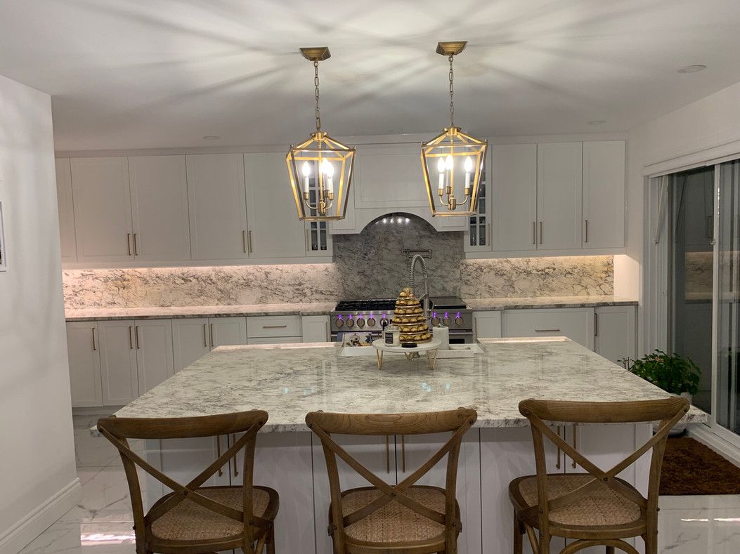 Une cuisine avec un grand îlot et des chaises et une cuisinière.