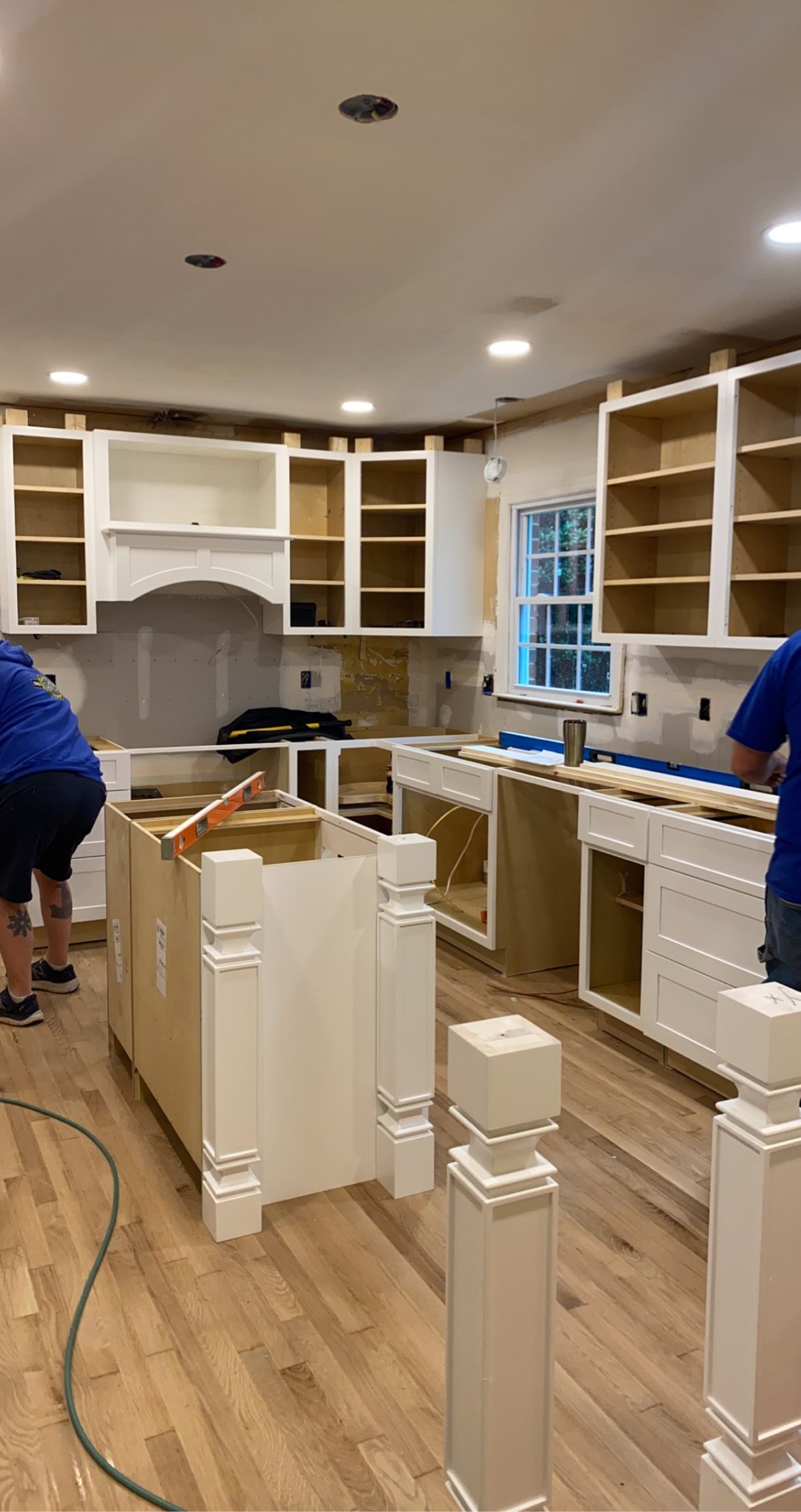 Kitchen remodel in progress: Unfinished white cabinets and island. 