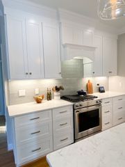 White kitchen cabinets with stainless steel appliances and light countertops.