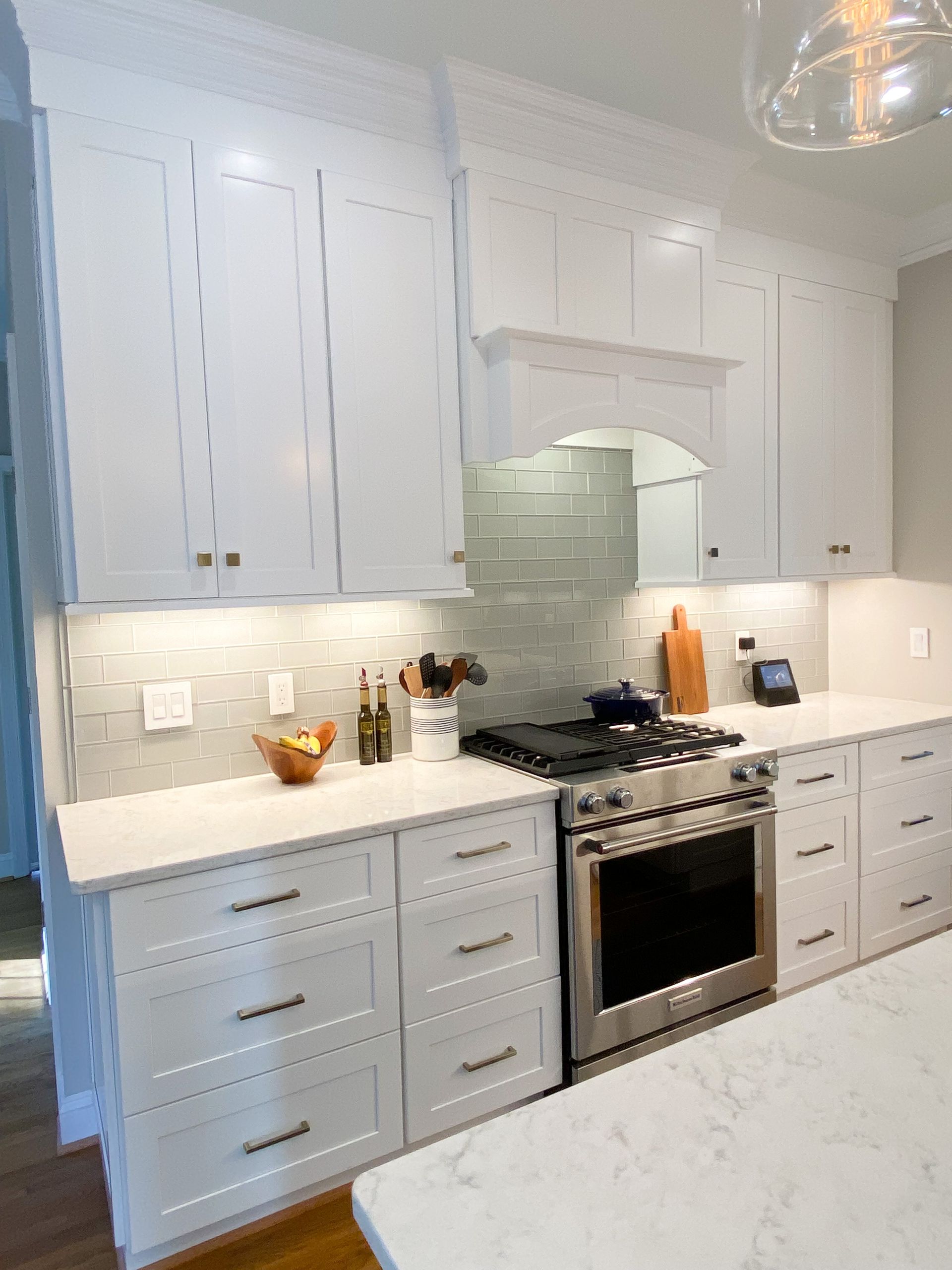 White kitchen cabinets with stainless steel appliances and light countertops.