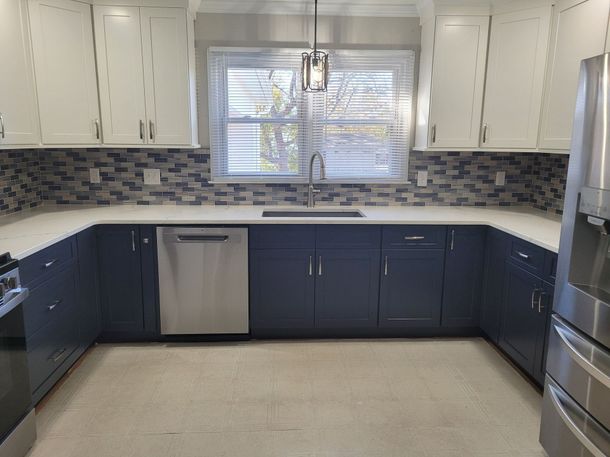 U-shaped kitchen with white upper cabinets.