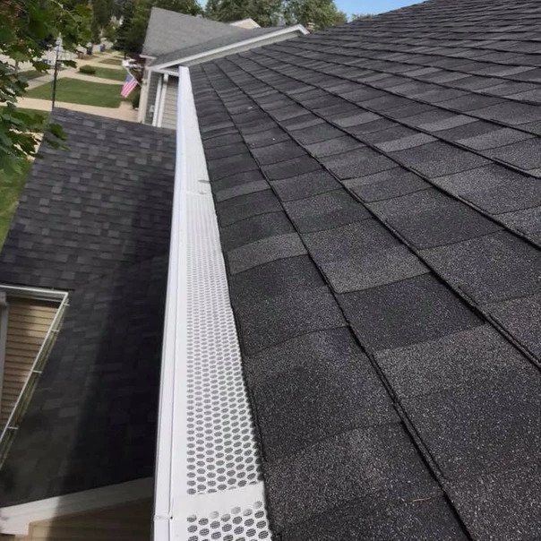 A black roof with a white gutter on the side of it.