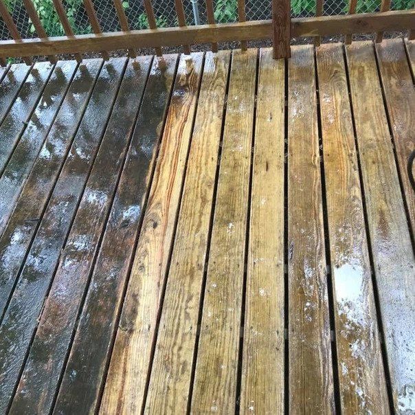 A wooden deck is being cleaned with a pressure washer.