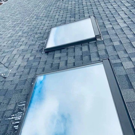 There are two skylights on the roof of a house.