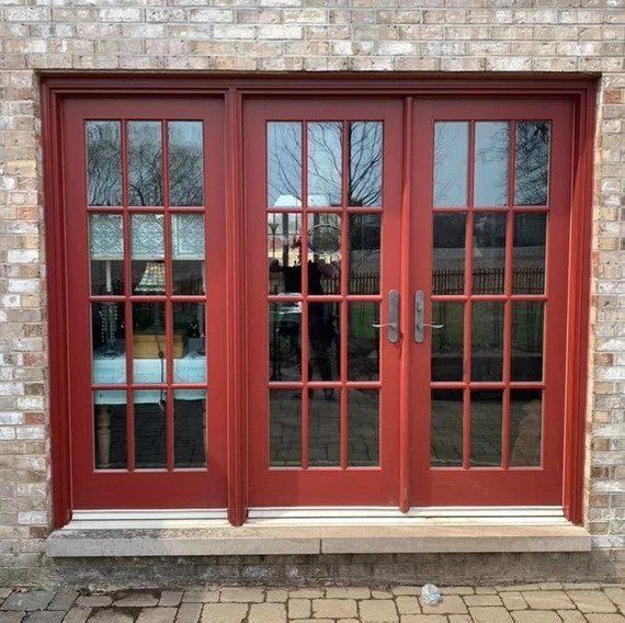 A pair of red french doors on a brick building