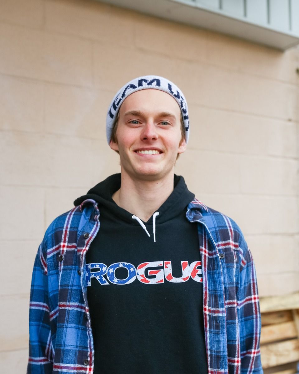 A man wearing a plaid shirt and a rogue hoodie