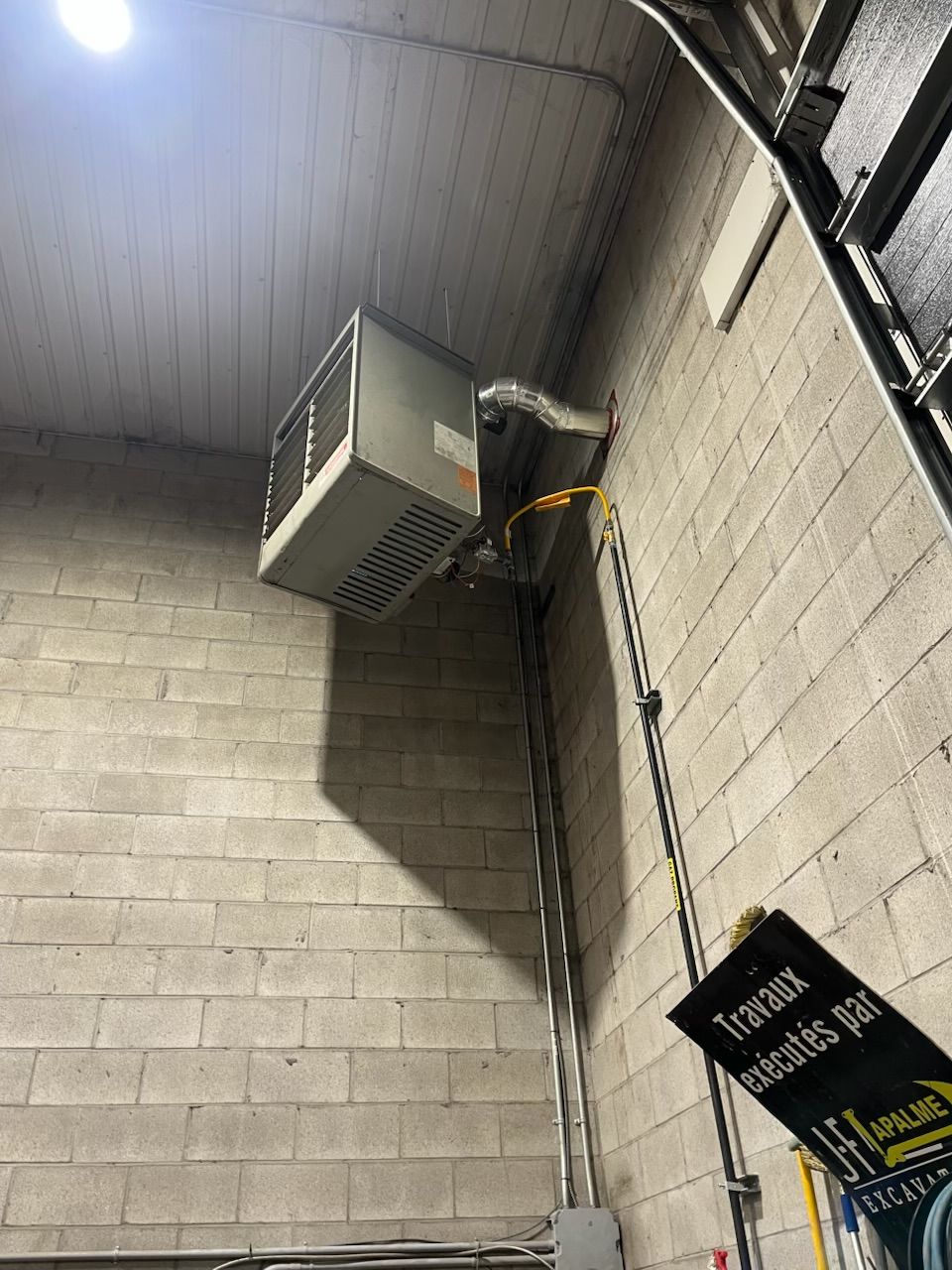 Un homme installe un radiateur sur un mur.