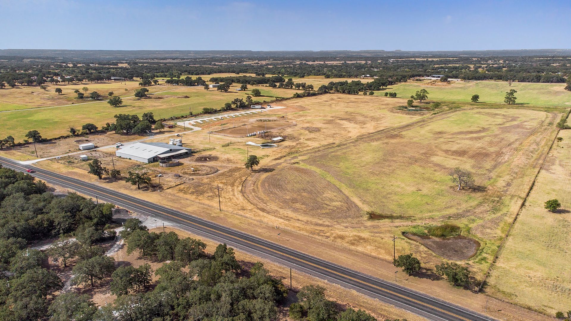 An aerial view of a large field next to a highway.