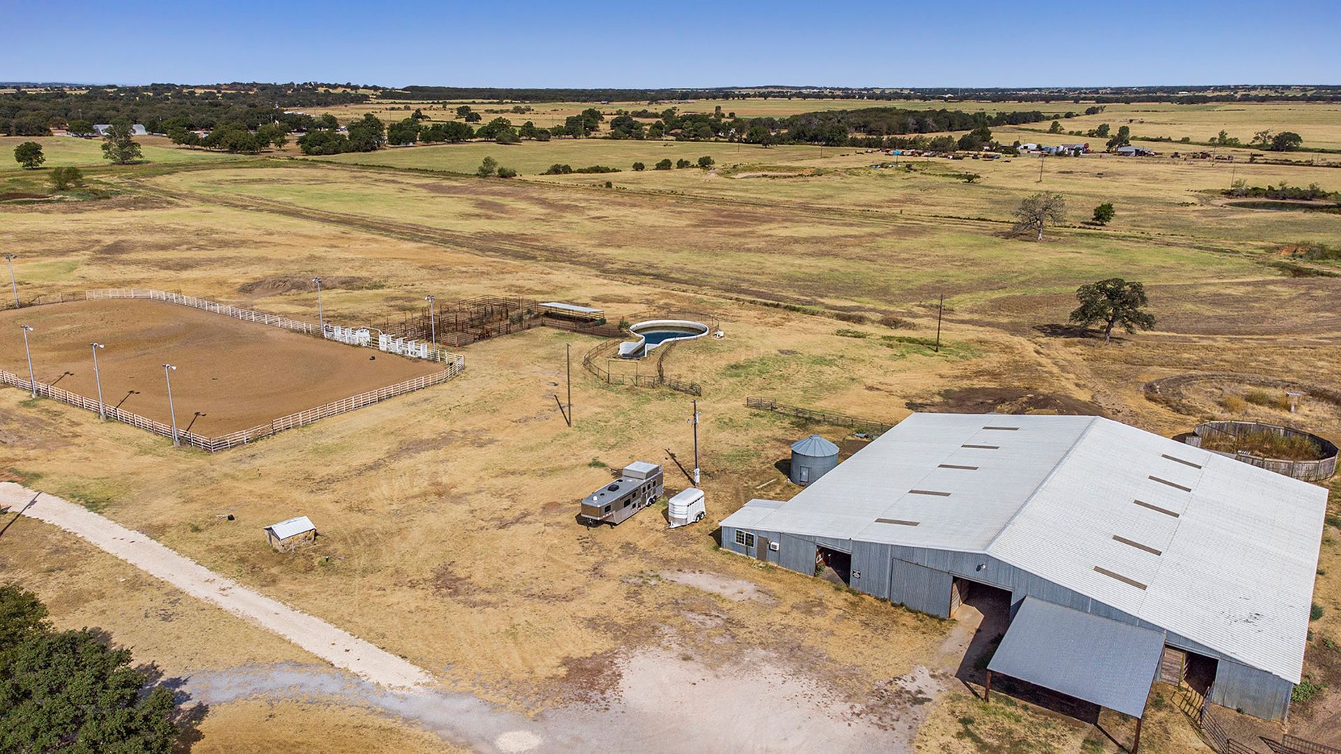 An aerial view of a large white building in the middle of a field.