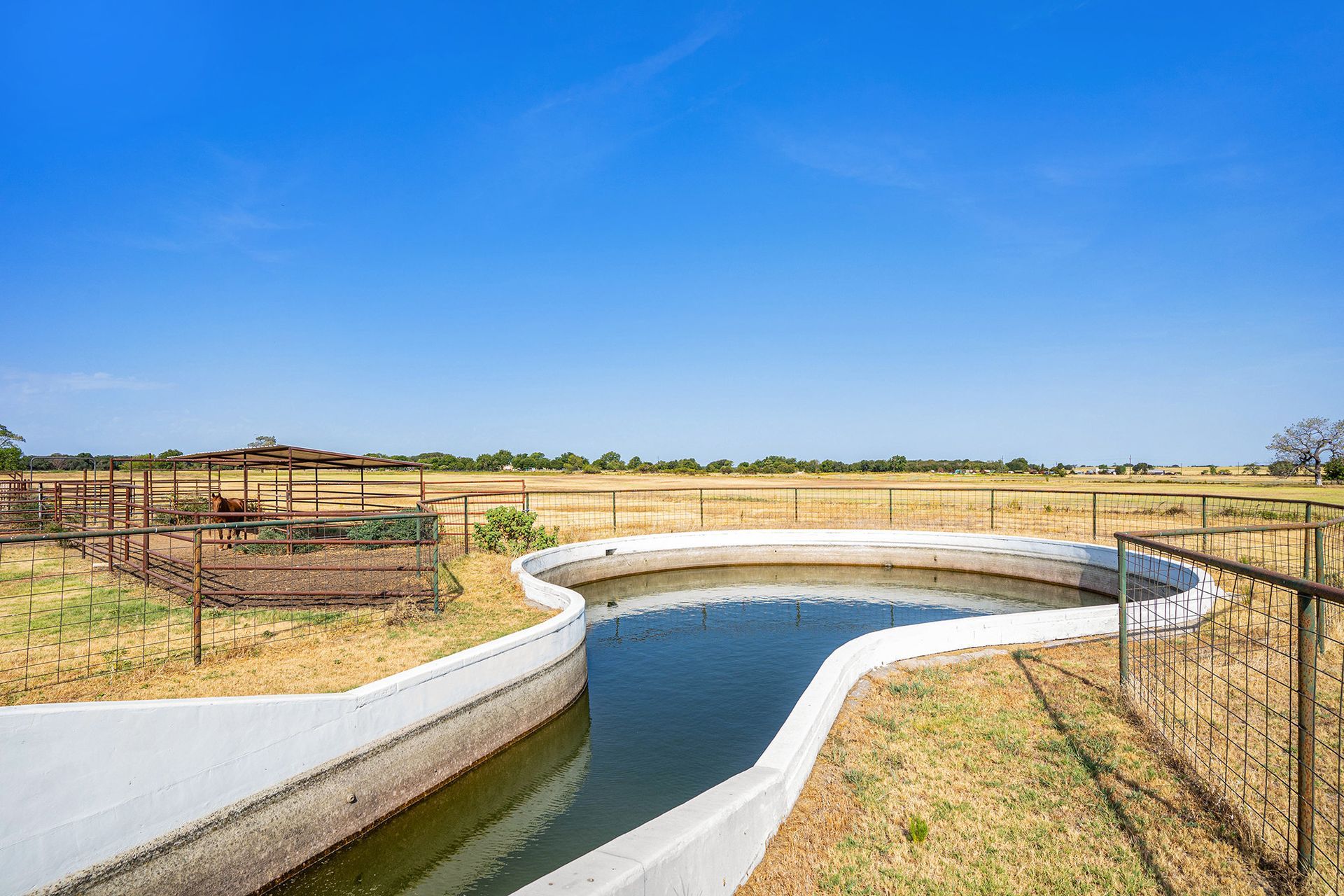 There is a large pool of water in the middle of a field.