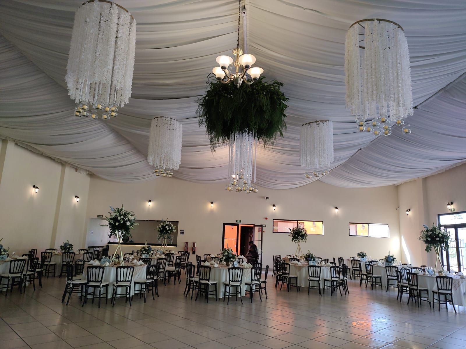 Una mesa con un mantel azul y sillas blancas