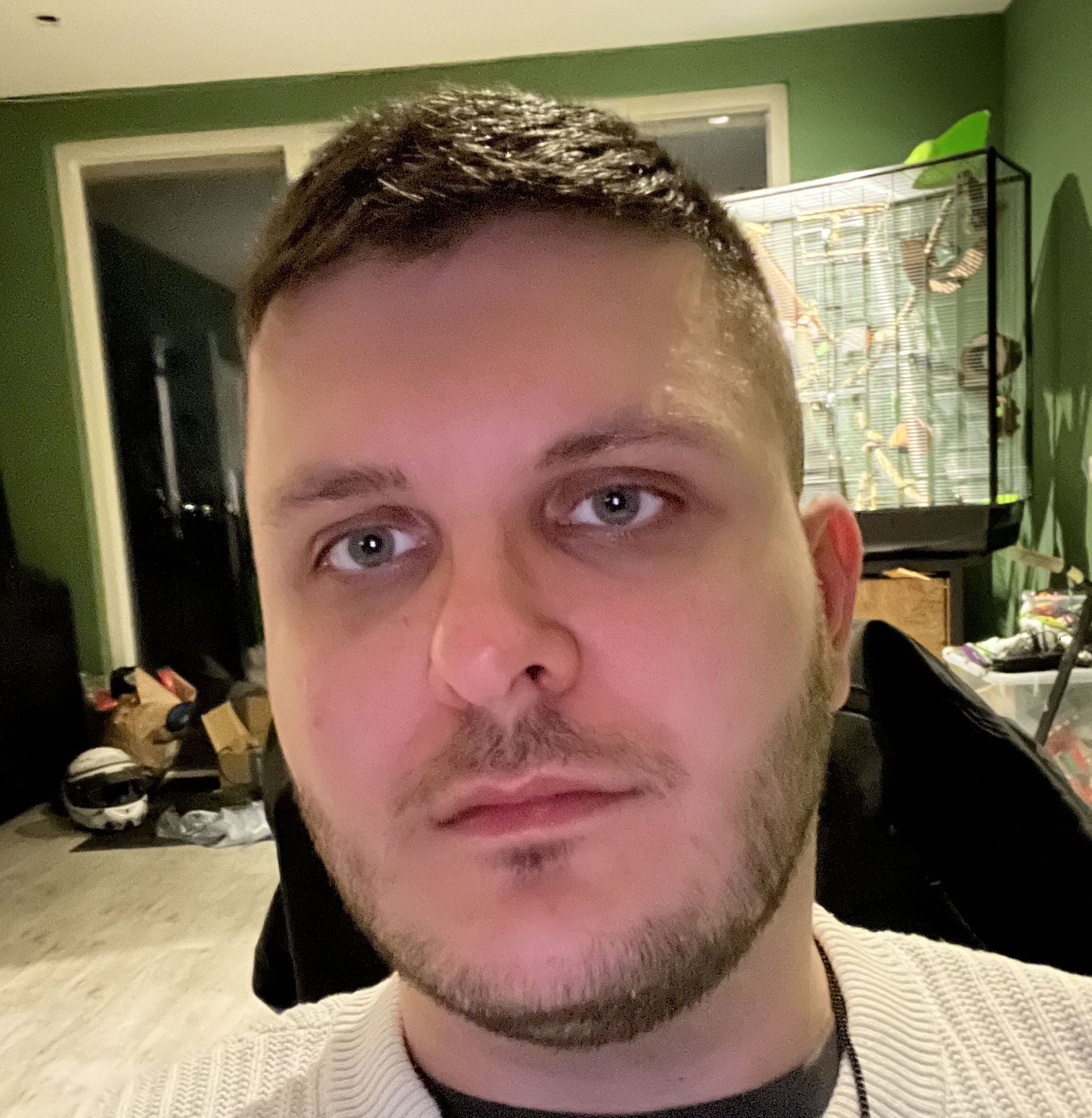 Een man met een baard kijkt naar de camera
