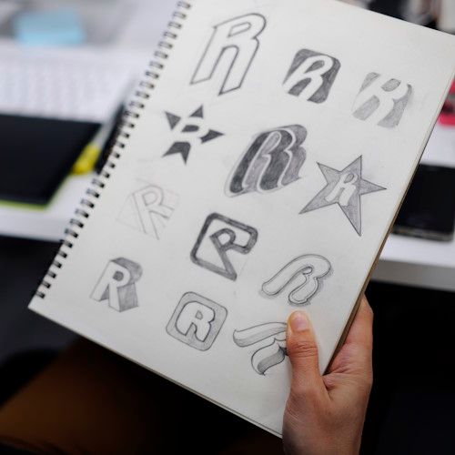 Logo ontwerpen - blad met een getekende stoel en een oranje liniaal
