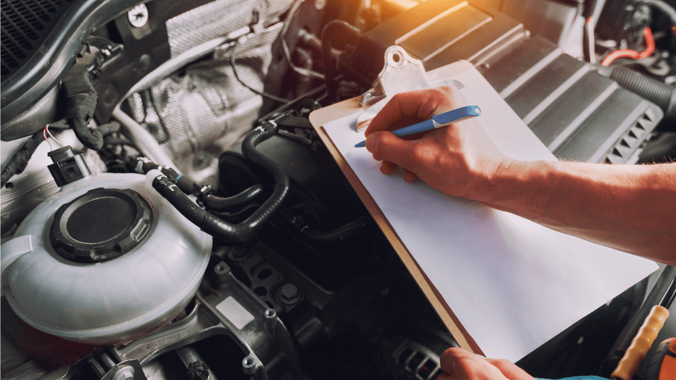 a mechanic taking notes during a pre-purchase inspection