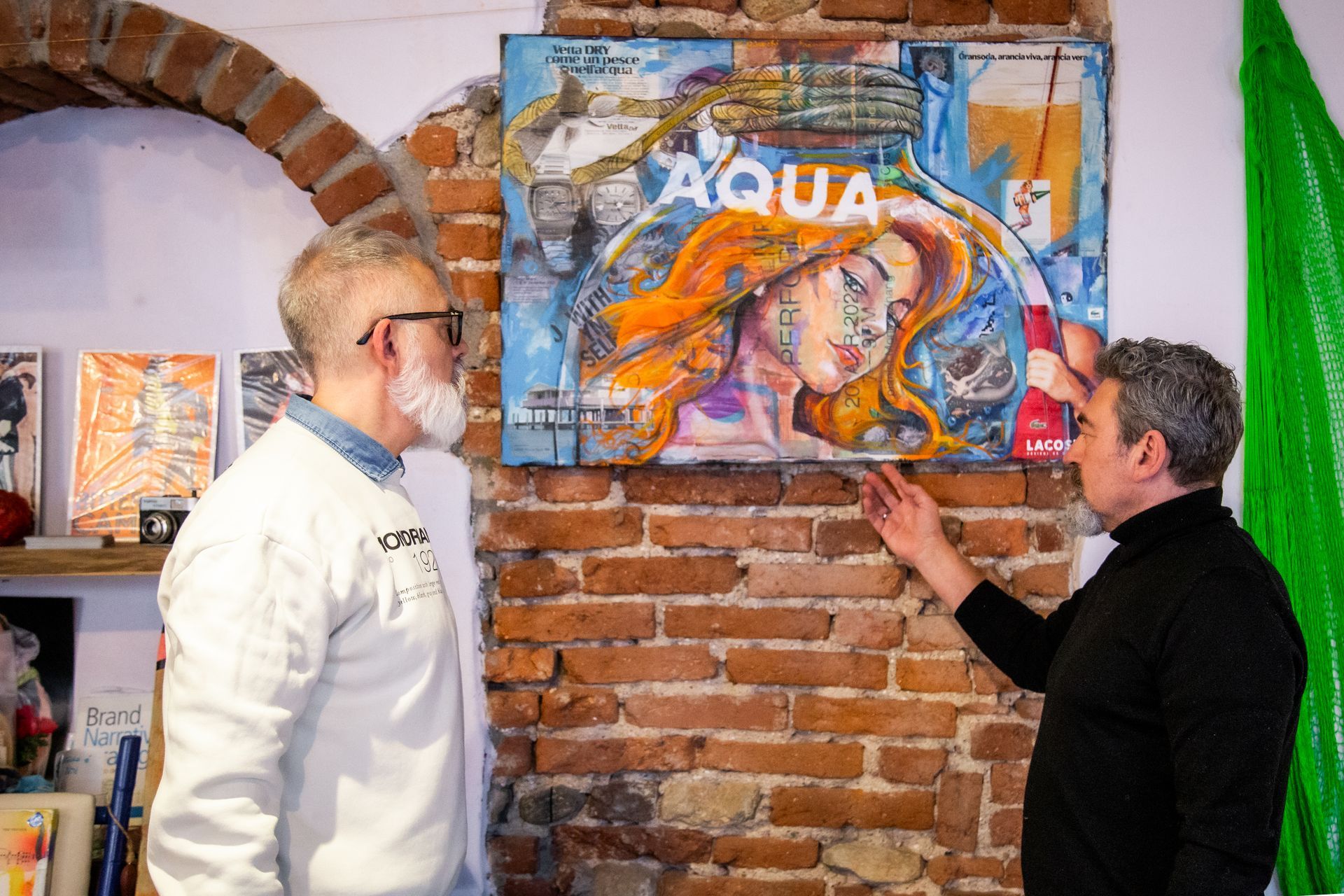 Due uomini sono in piedi davanti a un dipinto colorato intitolato 