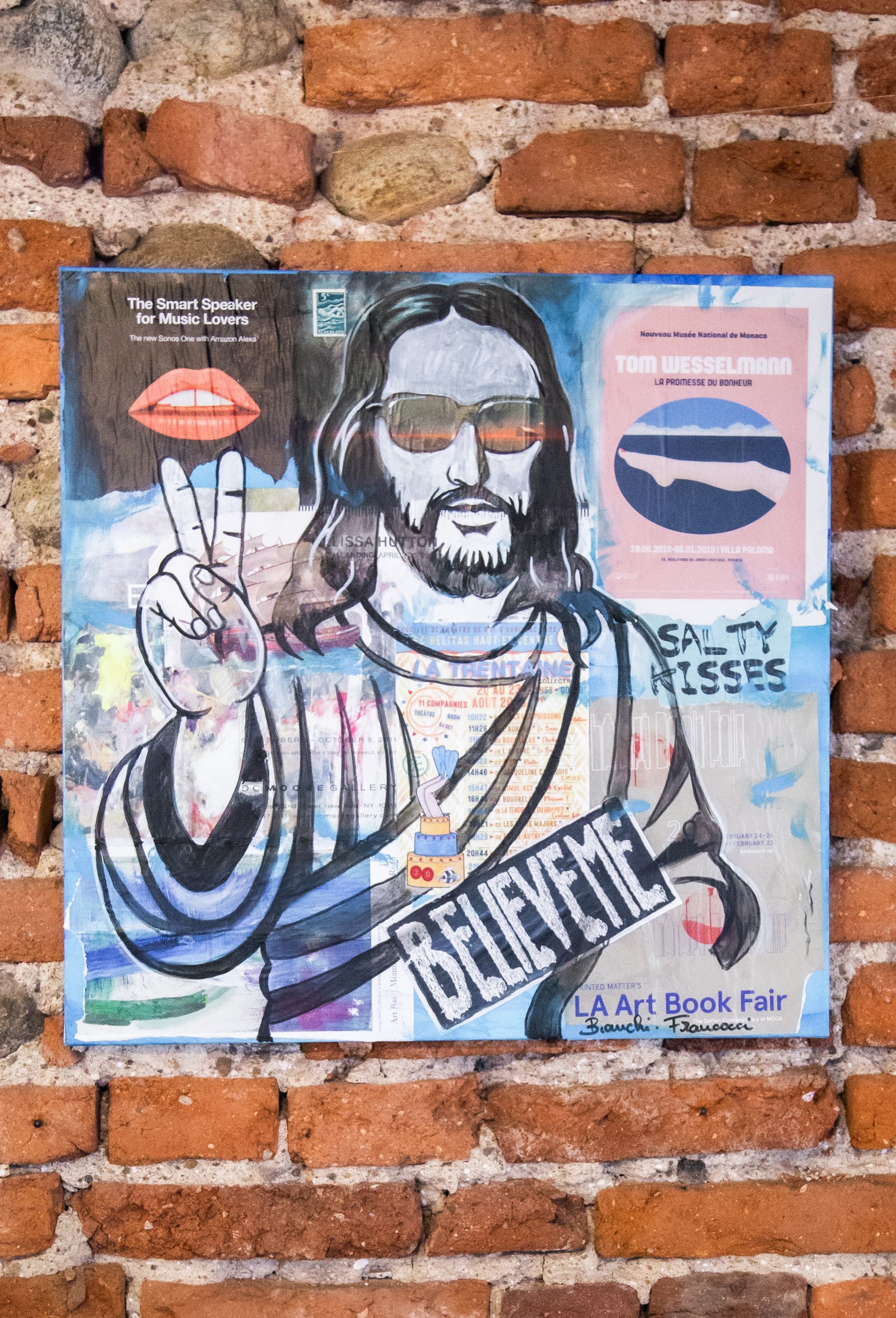 Una stampa artistica stilizzata di un uomo barbuto con occhiali da sole che fa il segno della pace, con la didascalia