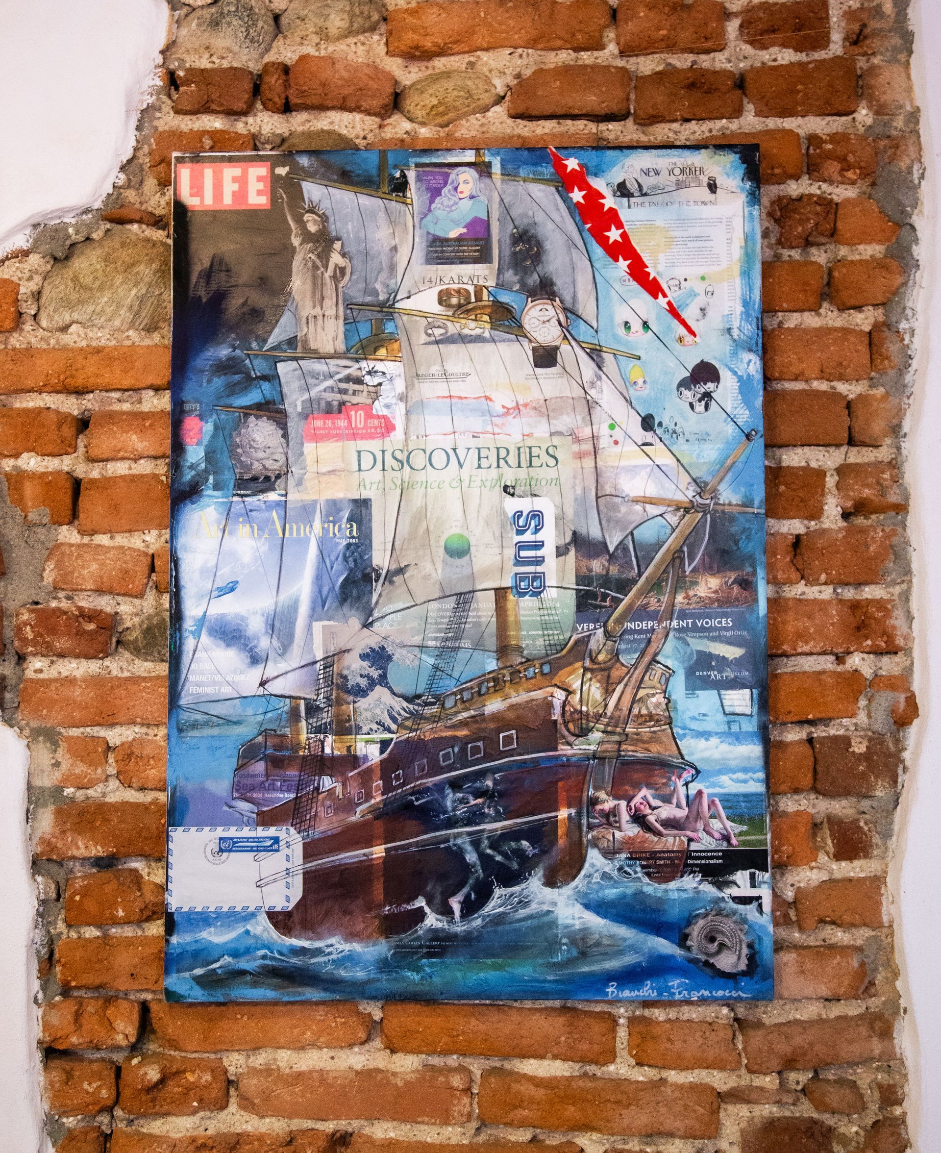 Un'opera d'arte a tecnica mista, un collage raffigurante una nave a vela, montata su un muro di mattoni a vista e invecchiato.