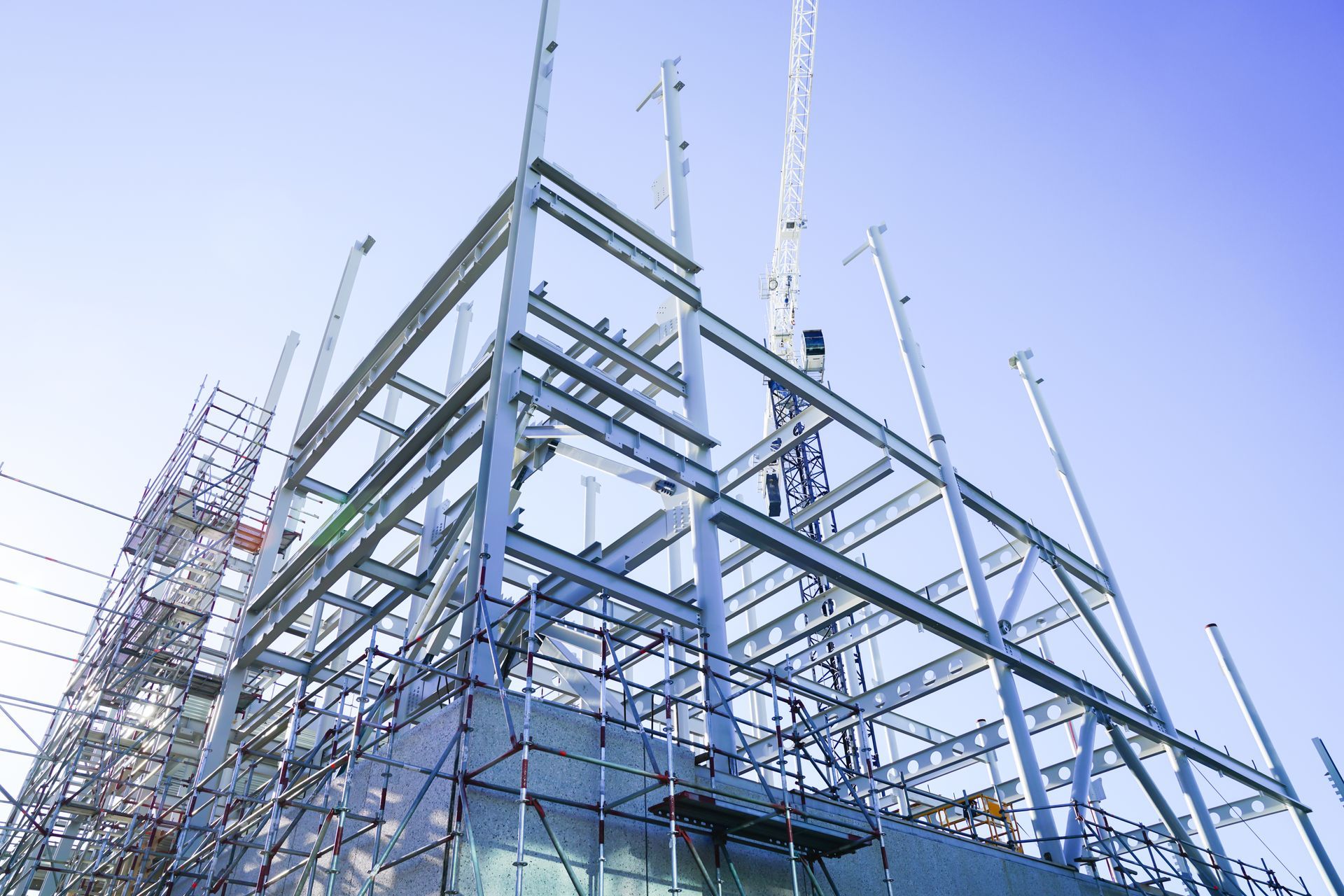 A large building is being built with scaffolding and a crane.