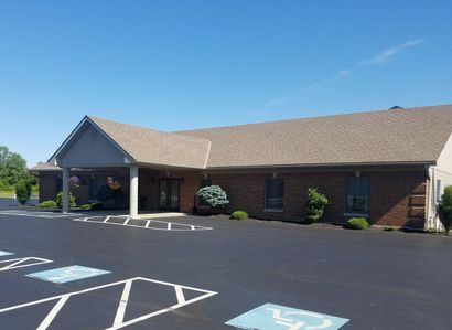 A large brick building with a handicapped parking spot in front of it.