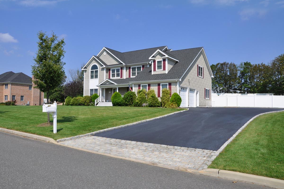 A large house with a driveway and a mailbox in front of it