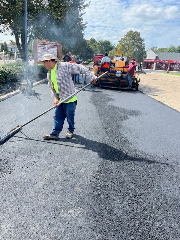 Two men are working on a road with shovels.