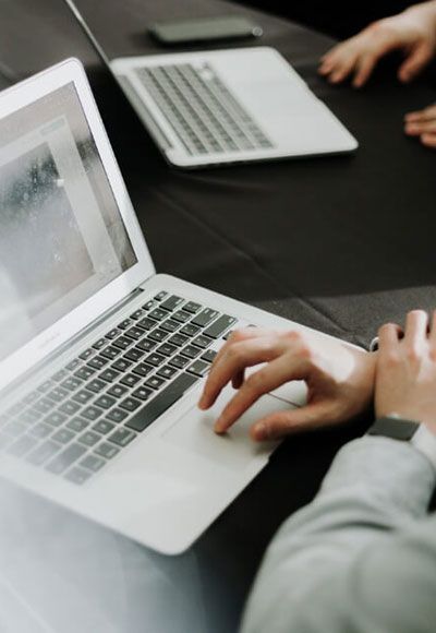 A person is typing on a laptop at a table