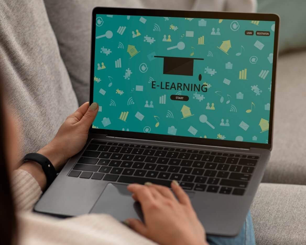 A woman is sitting on a couch using a laptop computer.