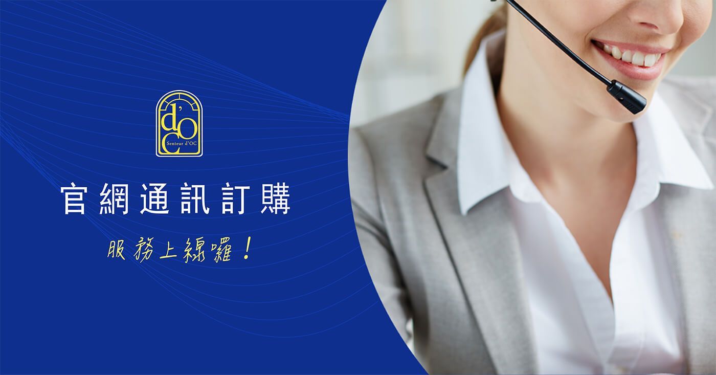 A woman in a suit is wearing a headset and smiling.