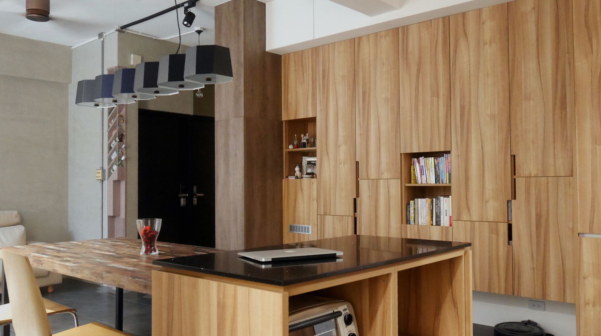 A kitchen with wooden cabinets and a table with a laptop on it.