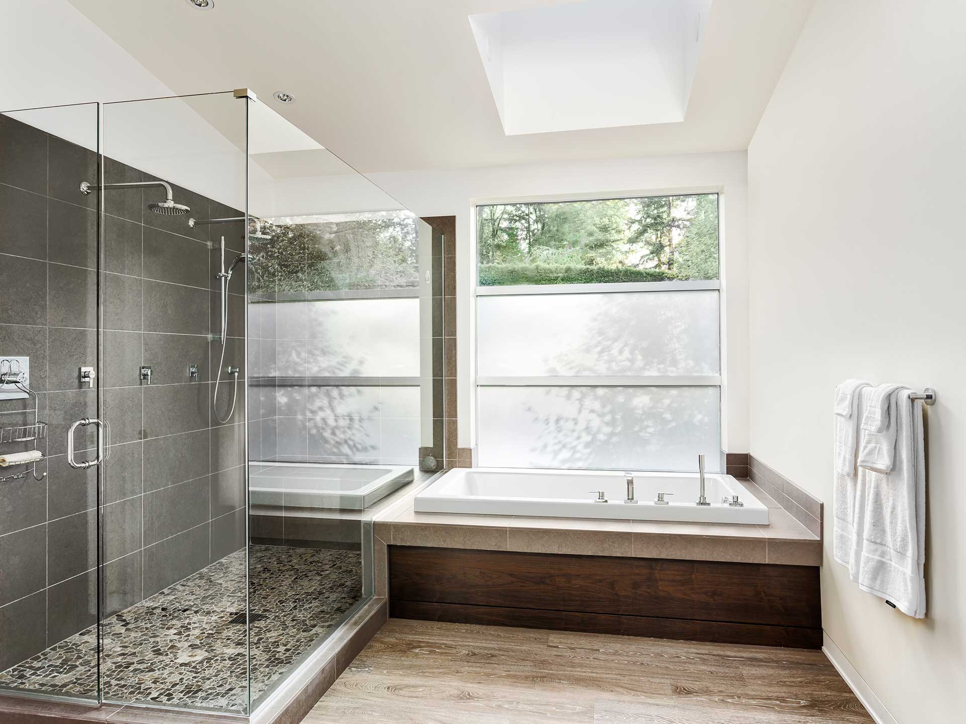 Modern bathroom with timber flooring and frameless shower screen