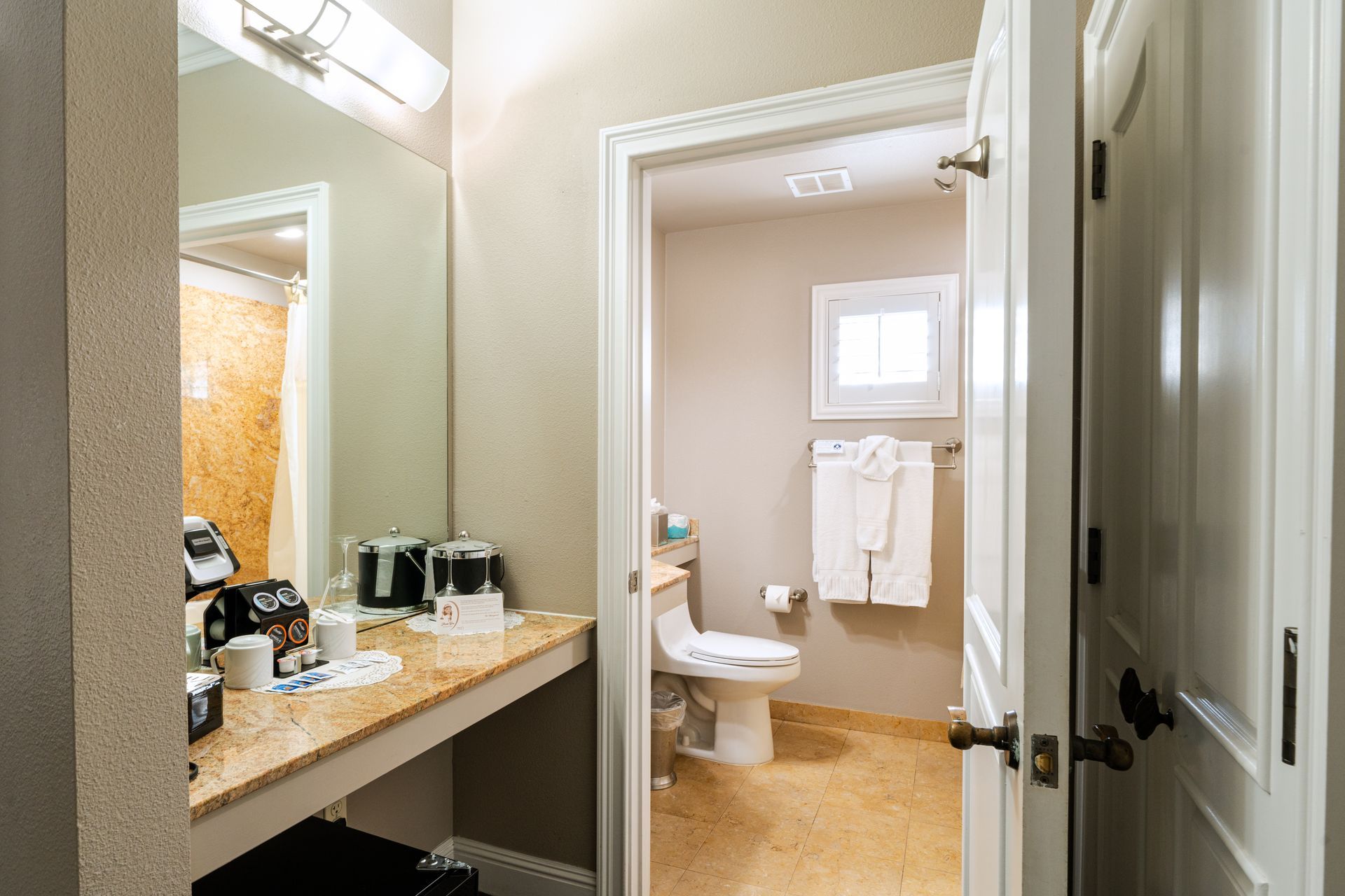 Bathroom with vanity, toilet, and doorway to a separate toilet/shower area.