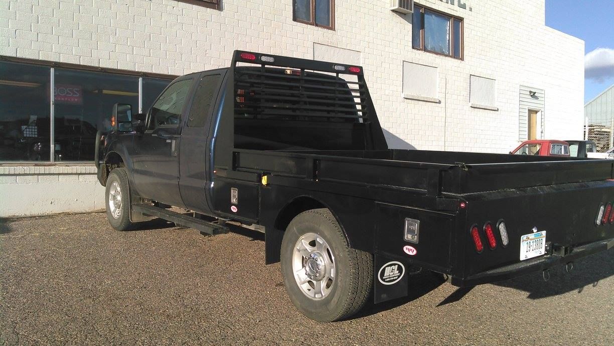 A White Dump Truck with A Red Bed Is Parked in A Parking Lot