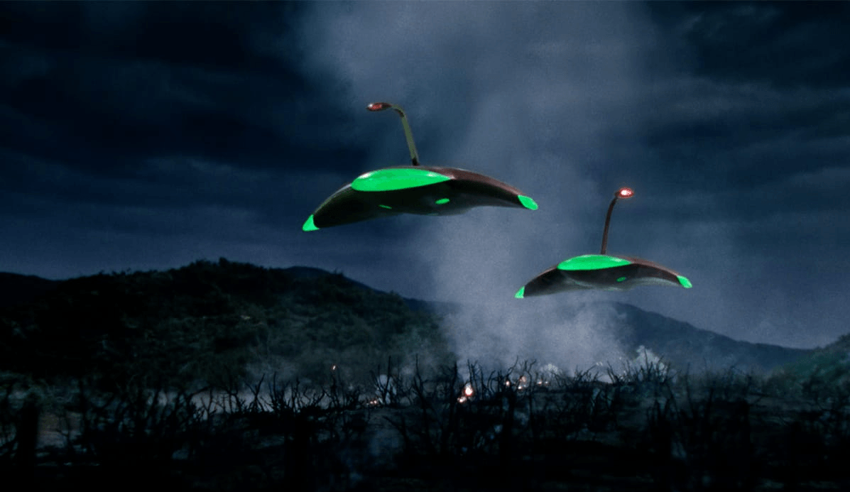 Two black and green Martian cylinders against a night time landscape - from the 1953 film version of The War Of The Worlds.