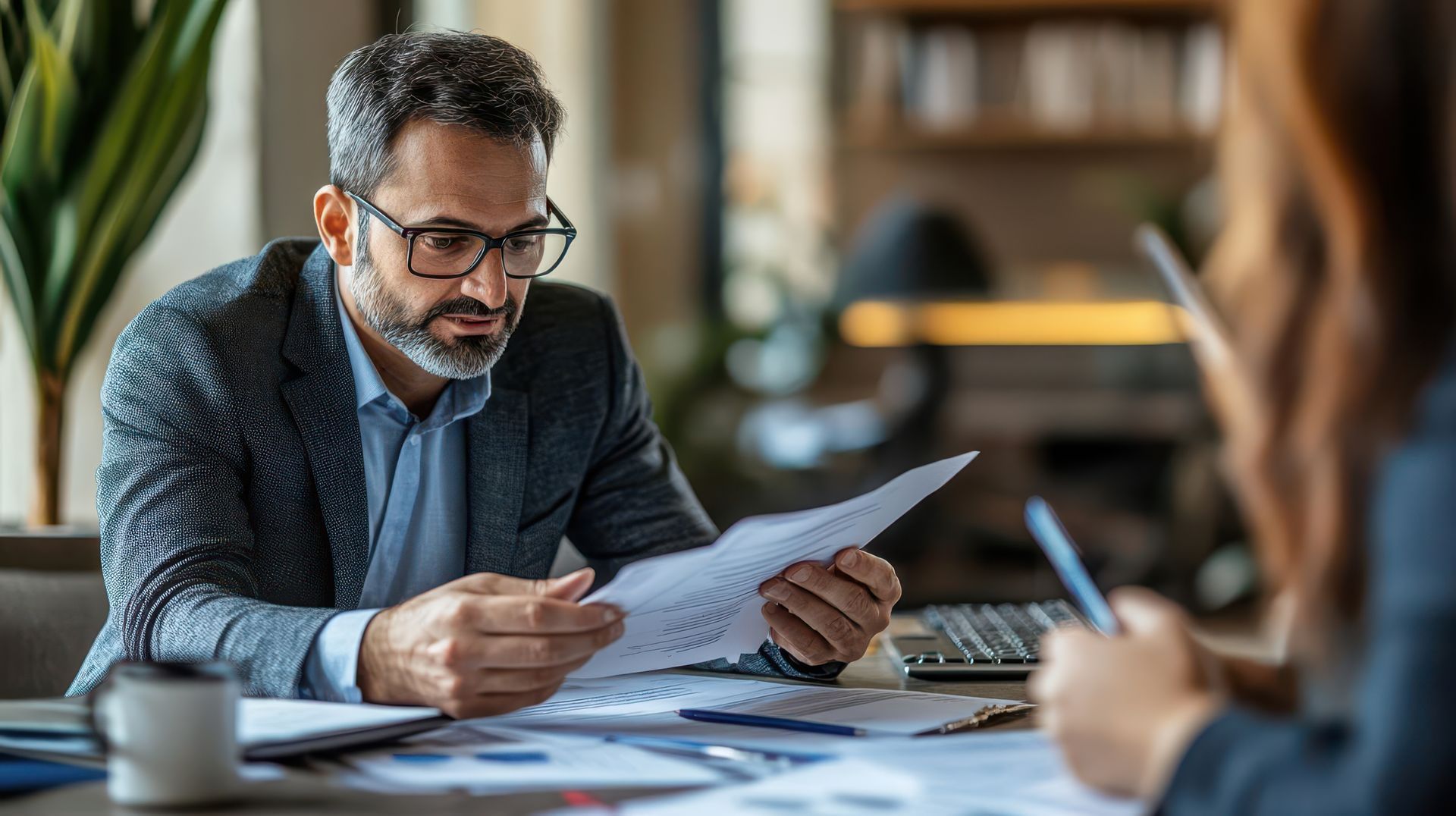 A professional advisor reviewing a loan program document during a consultation with a client.