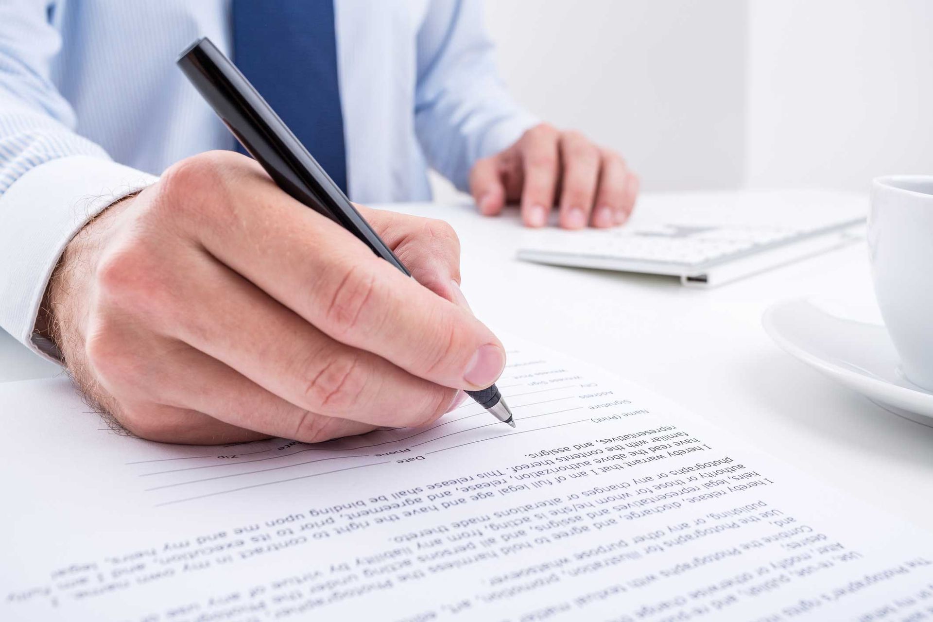 Businessman signing a service contract agreement document at office desk.