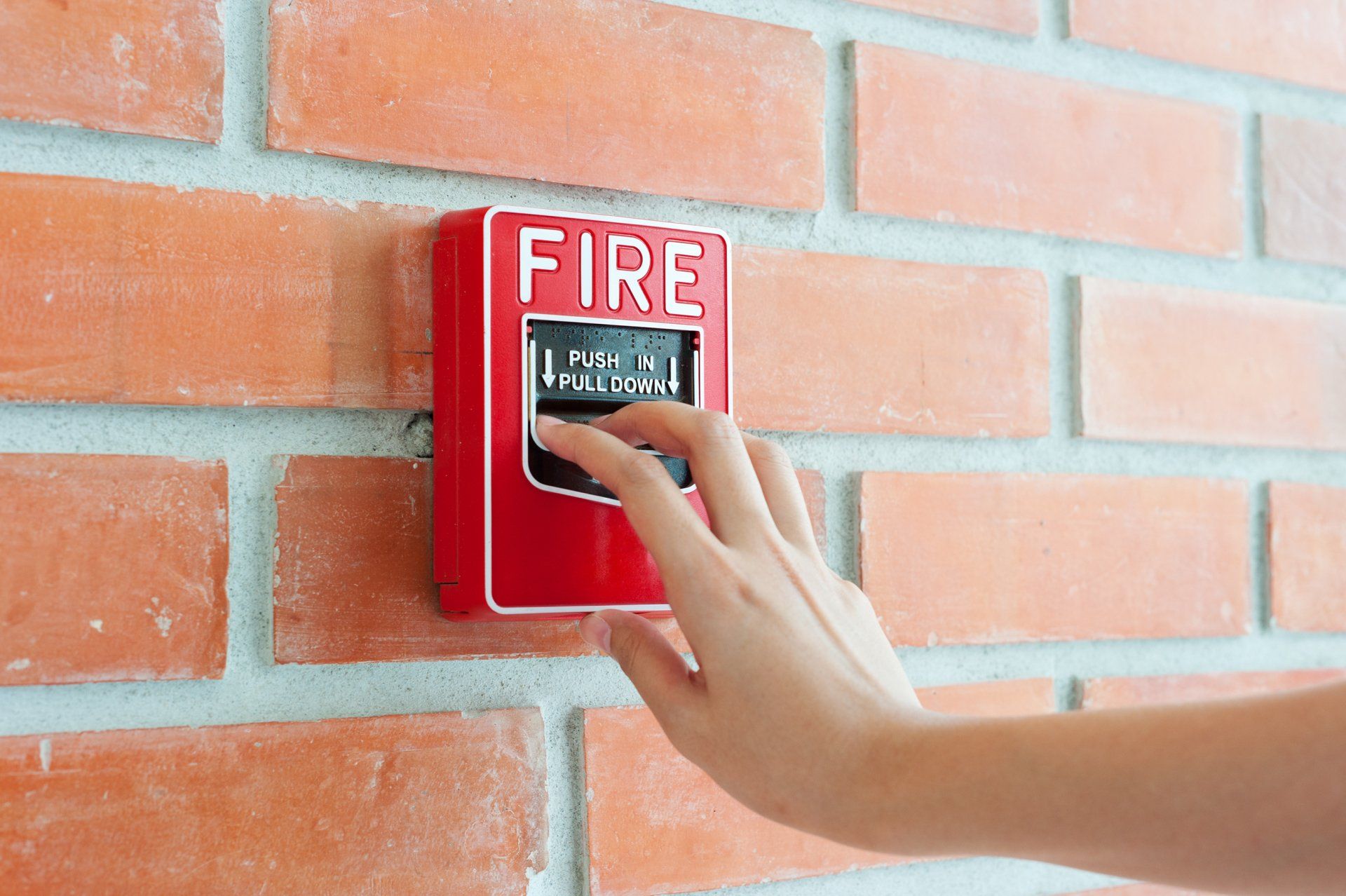 Hand Pulling Down Fire Alarm — Wilmington, NC — Sentinel Security Systems