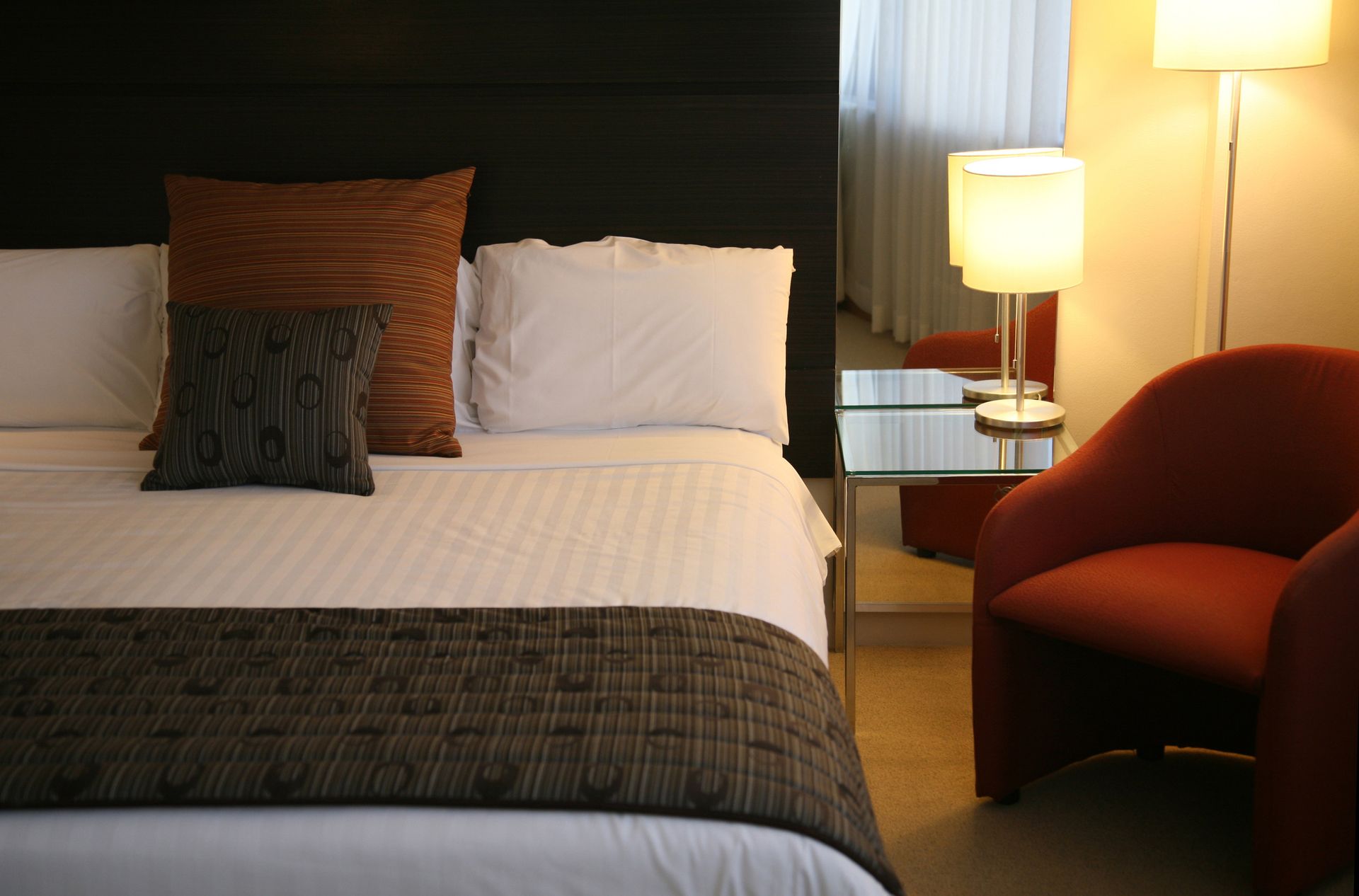 A hotel room with a king size bed and a chair.