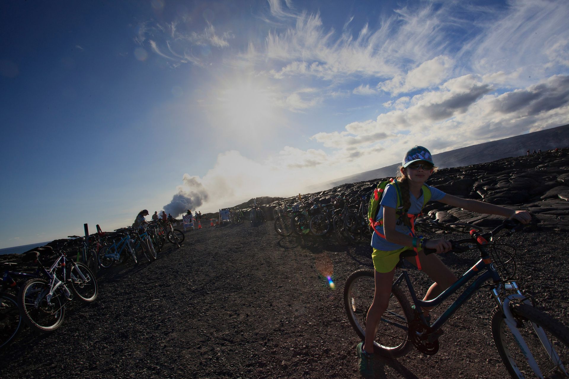 A woman is riding a bike on a dirt road.